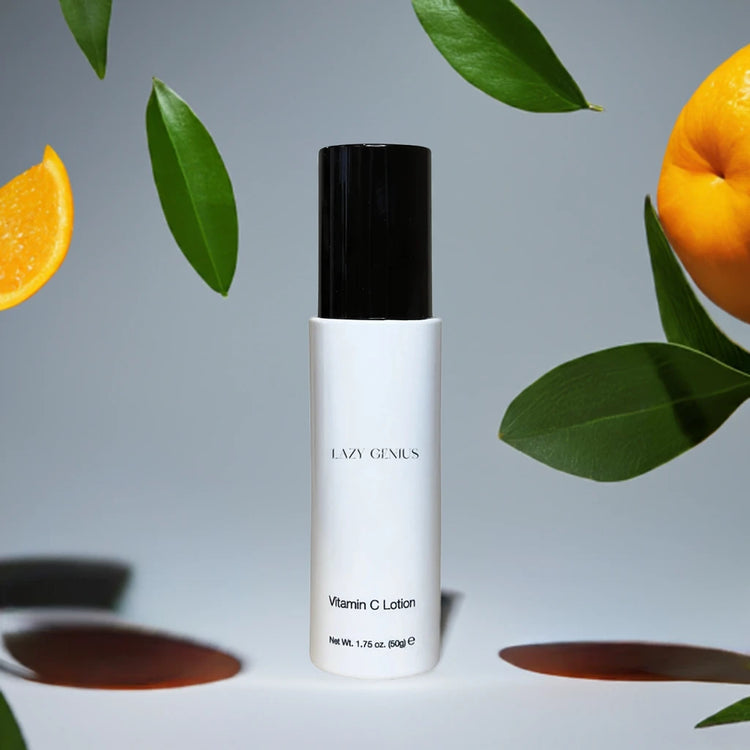 Lazy Genius Vitamin C Lotion surrounded by fresh orange slices and green leaves, showcasing vibrant skincare.